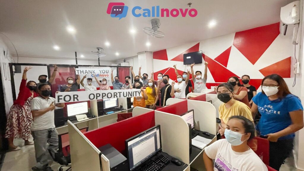 A group of Callnovo call center employees in the Philippines celebrating inside a modern customer service office.